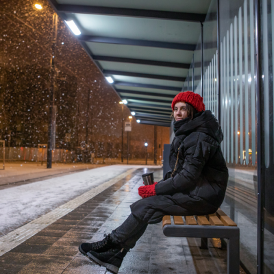 Osallisuus. Henkilö yksinään istumassa pysäkillä.